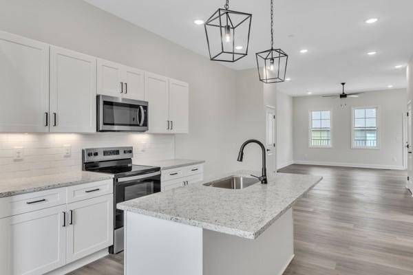179 Charleston Ave, Pleasant View, TN 37146 - kitchen with stainless steel appliances, wood finished floors, a center island with sink, ceiling fan, and recessed lighting