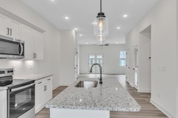 183 Charleston Ave, Pleasant View, TN 37146 - kitchen with stainless steel appliances, a kitchen island with sink, light wood-style floors, white cabinetry, and recessed lighting