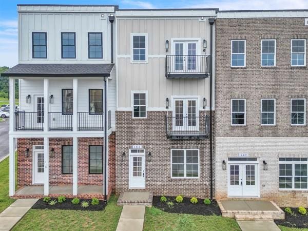183 Charleston Ave, Pleasant View, TN 37146 - townhome / multi-family property with french doors, board and batten siding, brick siding, and a balcony