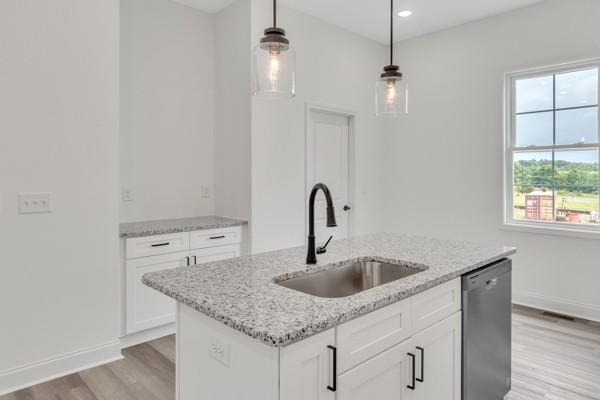 183 Charleston Ave, Pleasant View, TN 37146 - kitchen with stainless steel dishwasher, light wood-type flooring, decorative light fixtures, a center island with sink, and light stone countertops