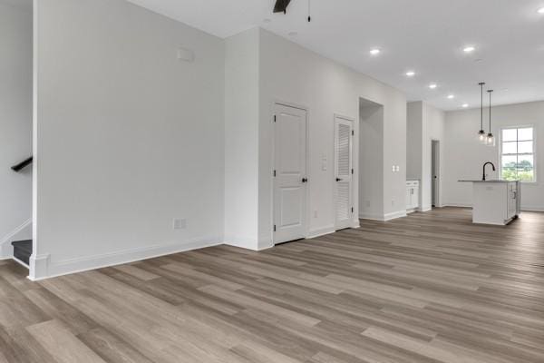 183 Charleston Ave, Pleasant View, TN 37146 - unfurnished living room featuring recessed lighting, light wood finished floors, ceiling fan, and stairs