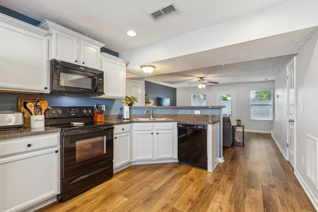 2058 Caladonia Way, Smyrna, TN 37167 - kitchen featuring black appliances, a peninsula, white cabinetry, light wood-type flooring, and recessed lighting