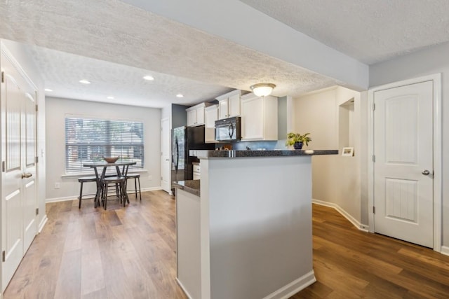 2058 Caladonia Way, Smyrna, TN 37167 - kitchen with black microwave, a textured ceiling, wood finished floors, white cabinetry, and recessed lighting