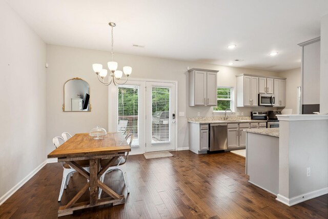 717 Monarchos Bnd, Burns, TN 37029 - kitchen featuring appliances with stainless steel finishes, a chandelier, dark wood finished floors, gray cabinetry, and pendant lighting