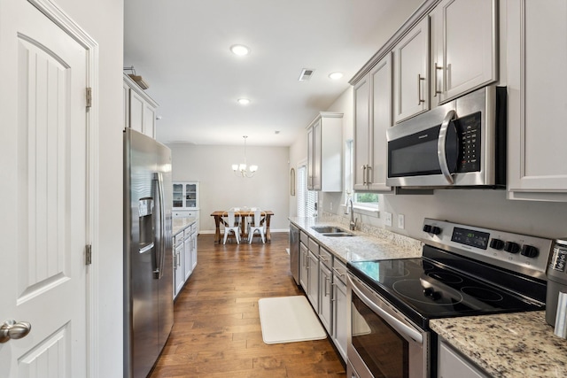 717 Monarchos Bnd, Burns, TN 37029 - kitchen with stainless steel appliances, a chandelier, dark wood-type flooring, recessed lighting, and light stone counters