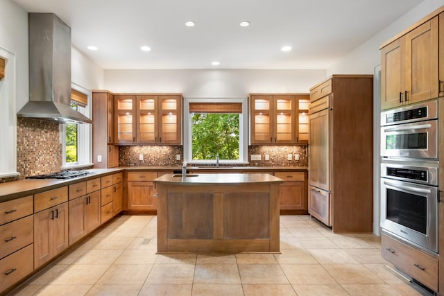 7909 Shoals Branch Rd, Primm Springs, TN 38476 - kitchen with island exhaust hood, stainless steel appliances, a center island with sink, backsplash, and light tile patterned floors