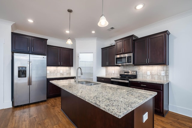 6055 Gracious Dr, Franklin, TN 37064 - kitchen with appliances with stainless steel finishes, dark brown cabinetry, crown molding, a kitchen island with sink, and backsplash