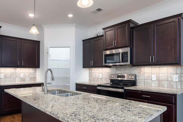6055 Gracious Dr, Franklin, TN 37064 - kitchen featuring appliances with stainless steel finishes, a center island with sink, dark brown cabinets, light stone counters, and tasteful backsplash