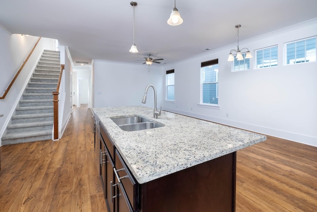 6055 Gracious Dr, Franklin, TN 37064 - kitchen with wood finished floors, dark brown cabinets, hanging light fixtures, and light stone countertops