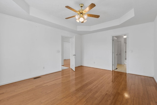 772 Blakemore Rd, Dickson, TN 37055 - unfurnished bedroom with a tray ceiling, light wood-style flooring, and a ceiling fan