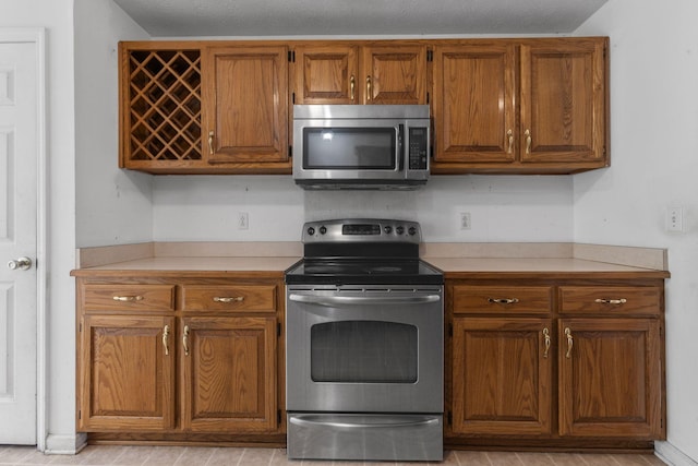 772 Blakemore Rd, Dickson, TN 37055 - kitchen featuring stainless steel appliances, brown cabinets, and light countertops