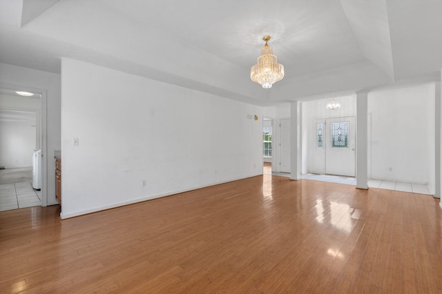 772 Blakemore Rd, Dickson, TN 37055 - unfurnished living room featuring a chandelier, light wood-type flooring, and a raised ceiling