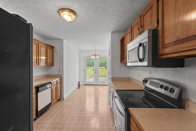 772 Blakemore Rd, Dickson, TN 37055 - kitchen featuring appliances with stainless steel finishes, light countertops, light floors, brown cabinetry, and a chandelier