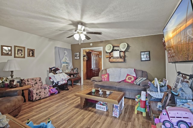 117 Hill Rd, Ardmore, TN 38449 - living area with wood finished floors, a ceiling fan, a textured ceiling, and cooling unit