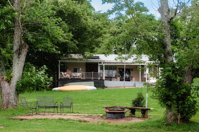 4295 Cairo Bend Rd, Lebanon, TN 37087 - rear view of house featuring an outdoor fire pit, a yard, a deck, and a metal roof