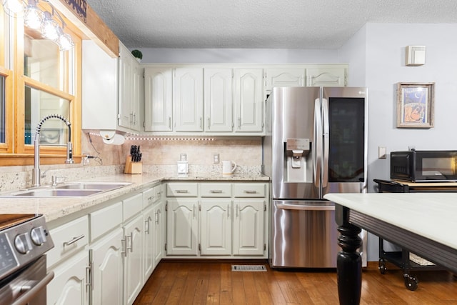 5719 Minor Hill Hwy, Goodspring, TN 38460 - kitchen featuring stainless steel appliances, dark wood-style flooring, a textured ceiling, light stone counters, and white cabinetry