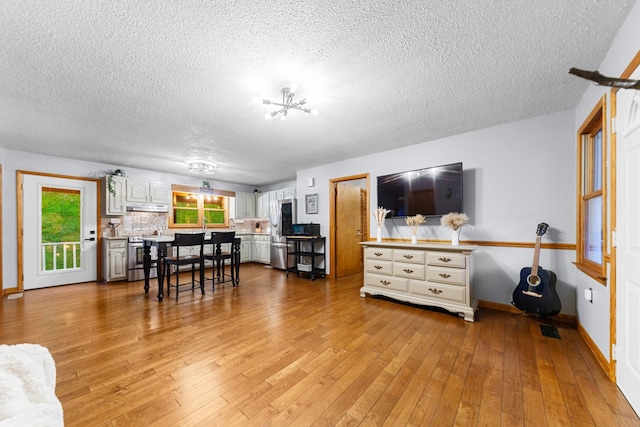 5719 Minor Hill Hwy, Goodspring, TN 38460 - living area featuring a textured ceiling, light wood finished floors, healthy amount of natural light, and a chandelier