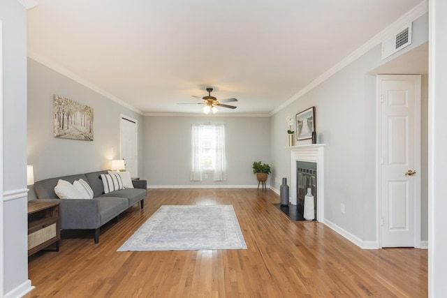 217 Ellington Pl, Madison, TN 37115 - living room with light wood-style flooring, a ceiling fan, ornamental molding, and a fireplace with flush hearth