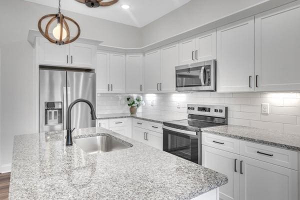 187 Charleston Ave, Pleasant View, TN 37146 - kitchen with appliances with stainless steel finishes, white cabinetry, tasteful backsplash, light stone counters, and recessed lighting