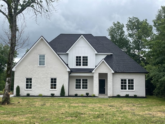 11497 Karo Rd, Bell Buckle, TN 37020 - view of front facade with board and batten siding, brick siding, a front yard, and roof with shingles