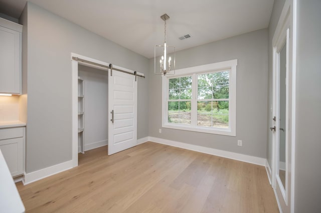 11497 Karo Rd, Bell Buckle, TN 37020 - unfurnished bedroom featuring a barn door and light wood-style floors