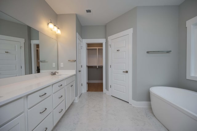 11497 Karo Rd, Bell Buckle, TN 37020 - full bathroom featuring marble look tile flooring, double vanity, a freestanding tub, and a spacious closet