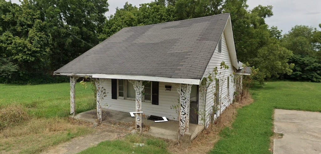 306 N Paradise Ave, Trenton, TN 38382 - view of front of house featuring a front yard, a shingled roof, and view of wooded area