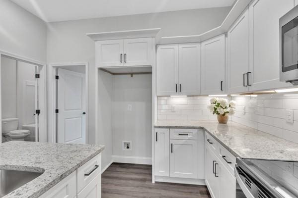 195 Charleston Ave, Pleasant View, TN 37146 - kitchen with stainless steel microwave, white cabinetry, tasteful backsplash, dark wood-style floors, and light stone counters