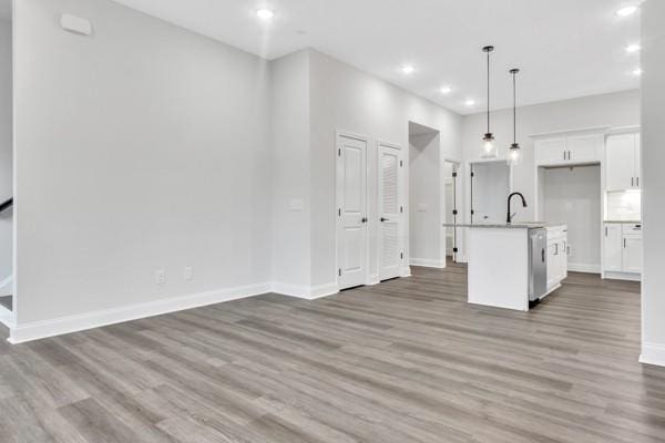 195 Charleston Ave, Pleasant View, TN 37146 - kitchen with white cabinetry, wood finished floors, decorative light fixtures, a kitchen island with sink, and recessed lighting