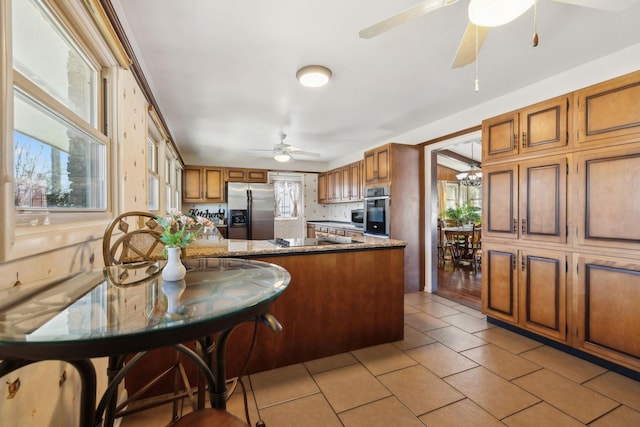 305 Myers Ter, Carthage, TN 37030 - kitchen with appliances with stainless steel finishes, brown cabinetry, a ceiling fan, a peninsula, and light tile patterned floors