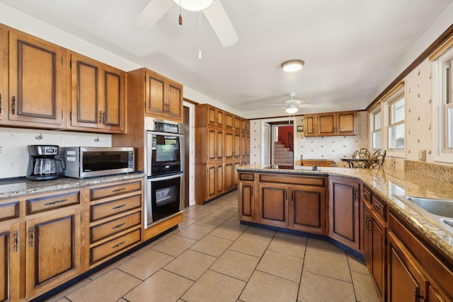 305 Myers Ter, Carthage, TN 37030 - kitchen with ceiling fan, stainless steel appliances, brown cabinetry, and light tile patterned floors