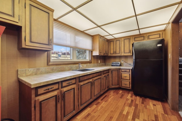 305 Myers Ter, Carthage, TN 37030 - kitchen with freestanding refrigerator, wood finished floors, tile counters, and brown cabinets