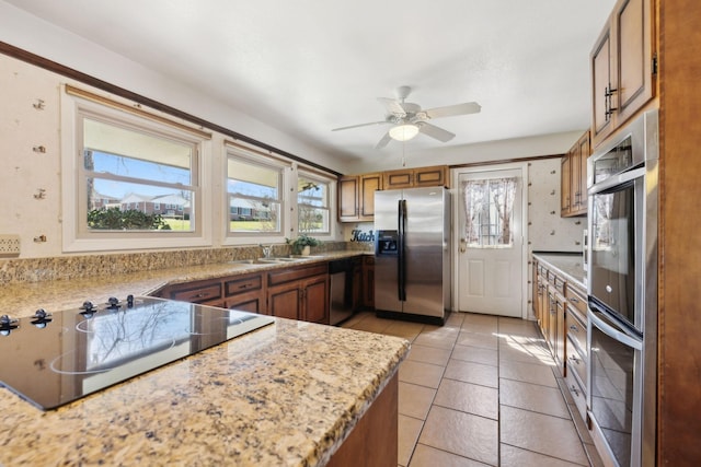 305 Myers Ter, Carthage, TN 37030 - kitchen with appliances with stainless steel finishes, brown cabinetry, ceiling fan, light tile patterned floors, and light stone counters
