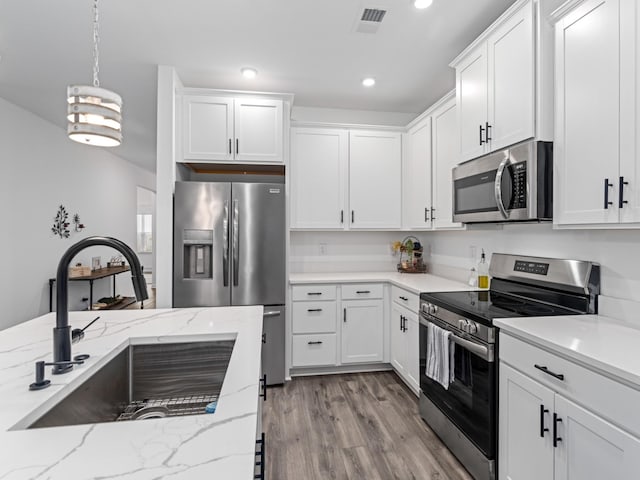 345 Winston Way, Gallatin, TN 37066 - kitchen with appliances with stainless steel finishes, light wood-style floors, white cabinets, decorative light fixtures, and recessed lighting
