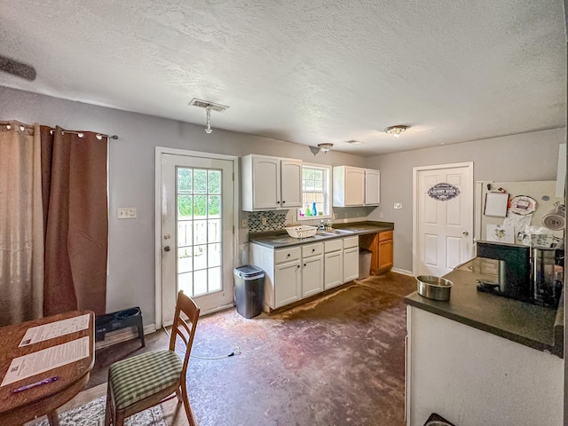 1097 Taylor Ln, Newbern, TN 38059 - kitchen with dark countertops, white cabinets, and a textured ceiling