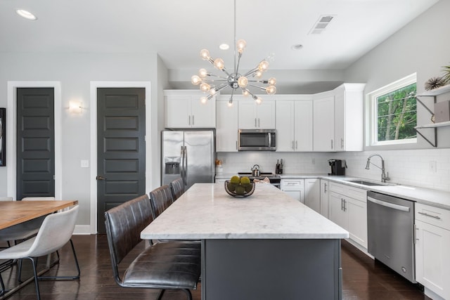 2410 Meharry Blvd Unit 3, Nashville, TN 37208 - kitchen with appliances with stainless steel finishes, a chandelier, backsplash, a breakfast bar, and dark wood-style flooring