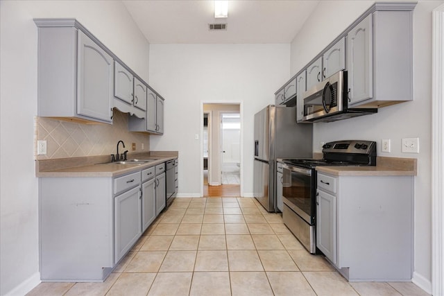 1117 Cross Wood Ln, Cordova, TN 38018 - kitchen featuring appliances with stainless steel finishes, gray cabinets, decorative backsplash, and light tile patterned floors