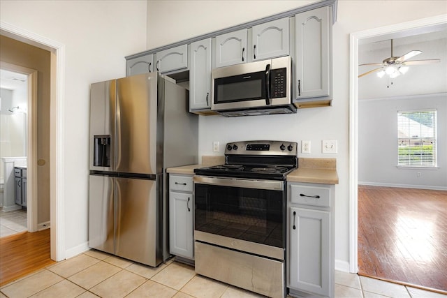 1117 Cross Wood Ln, Cordova, TN 38018 - kitchen with stainless steel appliances, gray cabinets, light wood-style floors, ceiling fan, and light countertops