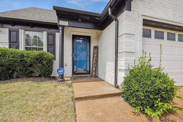 1117 Cross Wood Ln, Cordova, TN 38018 - doorway to property featuring a shingled roof, a garage, a yard, and brick siding