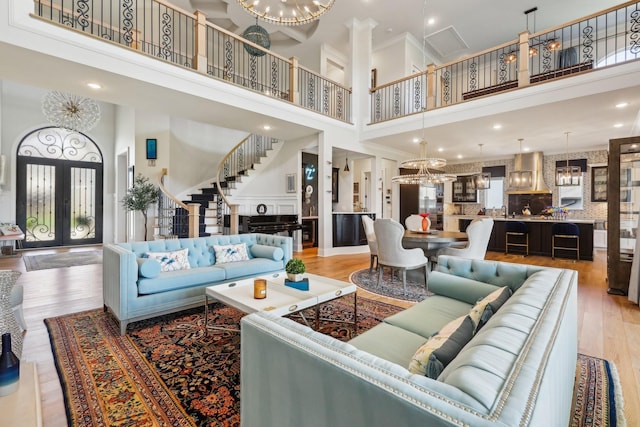 6004 Lookaway Cir, Franklin, TN 37067 - living room featuring a high ceiling, a chandelier, light wood-style flooring, stairs, and ornamental molding