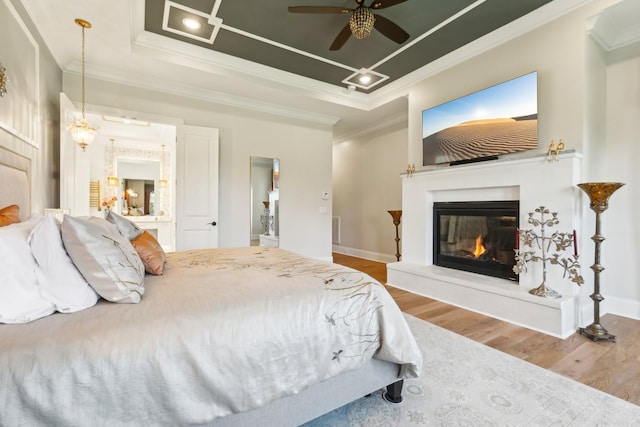 6004 Lookaway Cir, Franklin, TN 37067 - bedroom with a tray ceiling, wood finished floors, ornamental molding, a glass covered fireplace, and ceiling fan