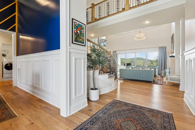 6004 Lookaway Cir, Franklin, TN 37067 - foyer entrance with a high ceiling, washer / dryer, stairs, wood finished floors, and a decorative wall
