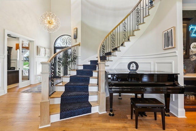 6004 Lookaway Cir, Franklin, TN 37067 - stairway featuring a decorative wall, a towering ceiling, a chandelier, wood finished floors, and a wainscoted wall