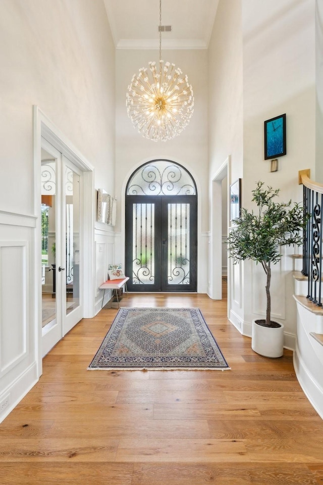 6004 Lookaway Cir, Franklin, TN 37067 - foyer entrance featuring french doors, crown molding, healthy amount of natural light, a chandelier, and a decorative wall