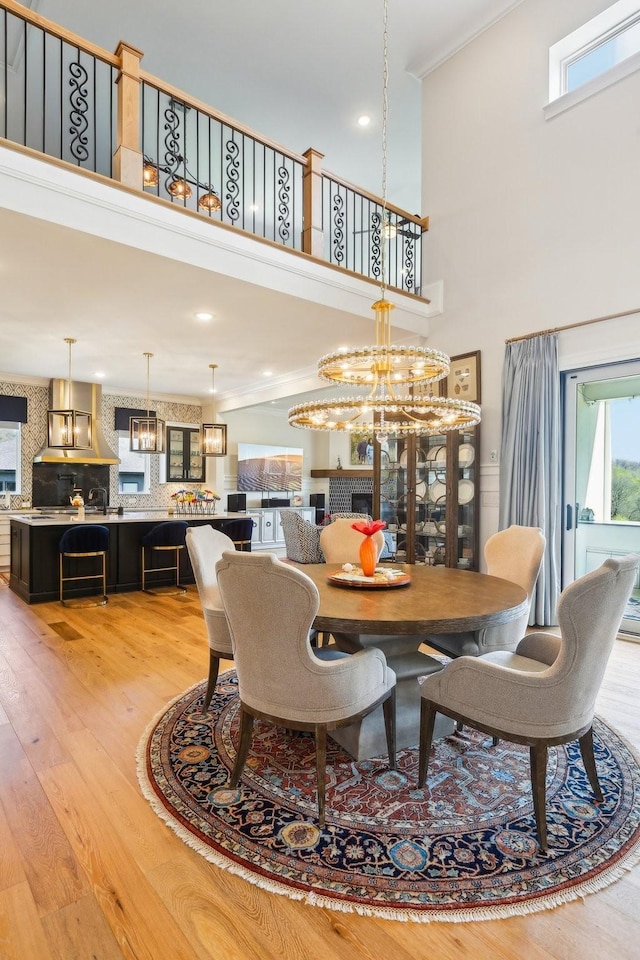 6004 Lookaway Cir, Franklin, TN 37067 - dining area featuring ornamental molding, light wood-style floors, a chandelier, a towering ceiling, and recessed lighting