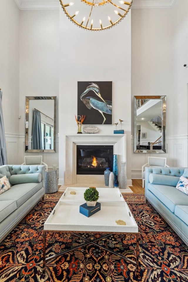6004 Lookaway Cir, Franklin, TN 37067 - living room with a high ceiling, crown molding, wood finished floors, wainscoting, and a glass covered fireplace