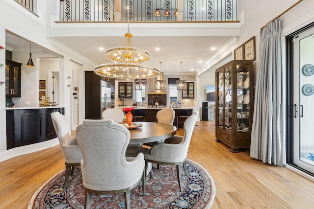 6004 Lookaway Cir, Franklin, TN 37067 - dining room with ornamental molding, a chandelier, light wood-style floors, a towering ceiling, and recessed lighting