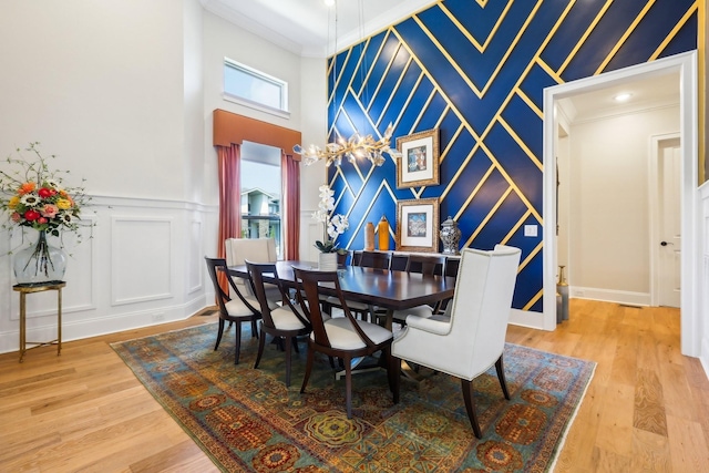 6004 Lookaway Cir, Franklin, TN 37067 - dining space with a decorative wall, ornamental molding, light wood-style floors, and a high ceiling