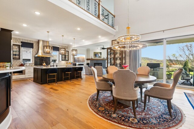 6004 Lookaway Cir, Franklin, TN 37067 - dining area with plenty of natural light, a brick fireplace, light wood-type flooring, crown molding, and recessed lighting