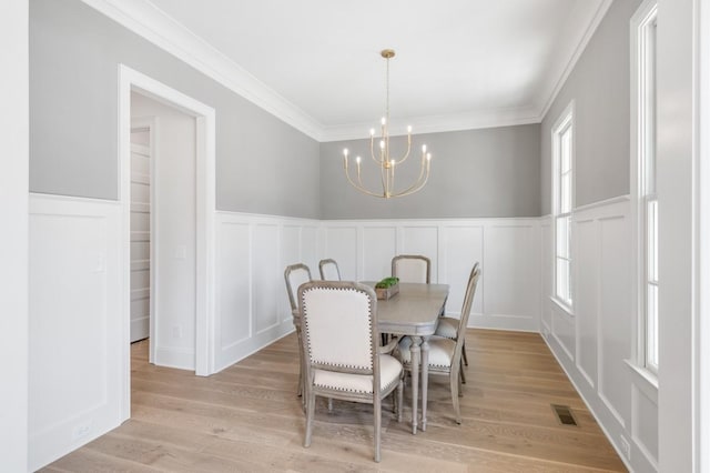 7018 Southvale Blvd, Franklin, TN 37064 - dining room featuring a decorative wall, a chandelier, crown molding, a wainscoted wall, and light wood-type flooring